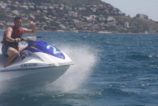 chico saludando desde la moto de agua